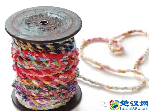 她把旧衣服剪成布条扭一扭，废物利用