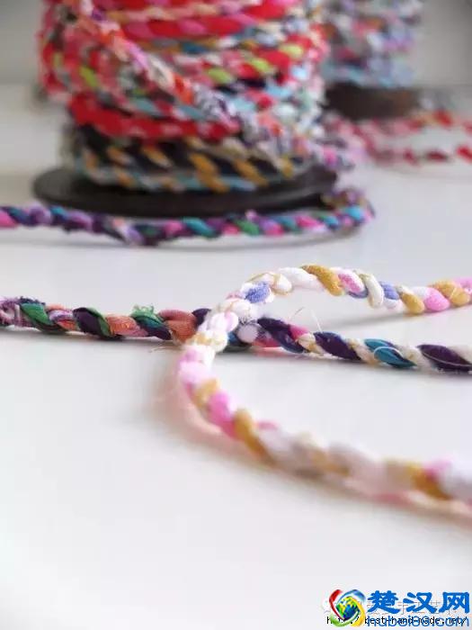 她把旧衣服剪成布条扭一扭，废物利用