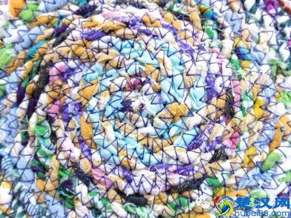 她把旧衣服剪成布条扭一扭，废物利用